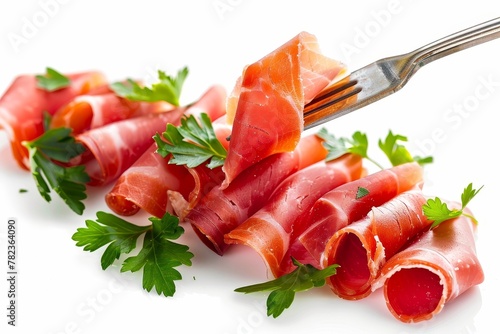 Serrano ham on fork with parsley white background