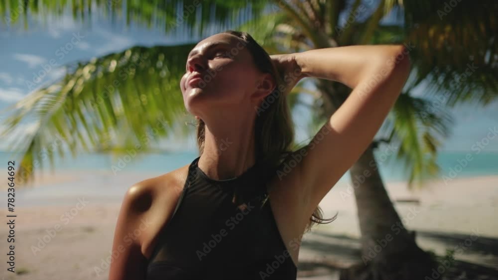 A woman dressed in a wet suit is standing on a sandy beach, with waves crashing behind her and the ocean stretching into the horizon. A woman dressed in a wet suit is standing on a sandy beach, with waves crashing behind her and the ocean stretching into the horizon.