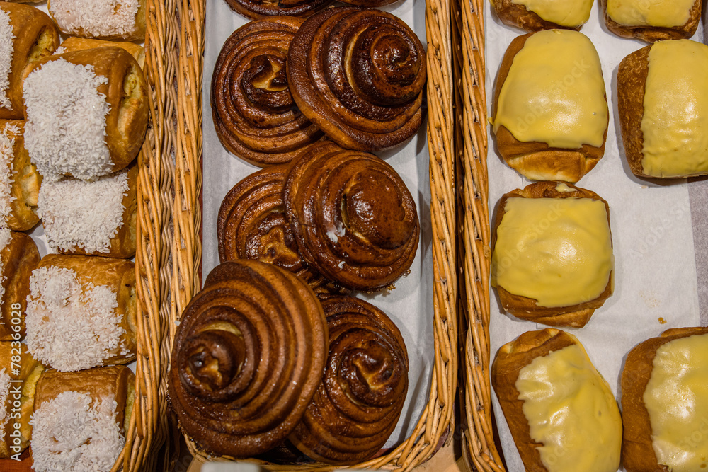 A lot of sweet pastries in baskets on the counter in the food store. Bakery on the buffet table. Business breakfasts and catering at events. Various bread type on shelf. Close-up. Selective focus. A lot of sweet pastries in baskets on the counter in the food store. Bakery on the buffet table. Business breakfasts and catering at events. Various bread type on shelf. Close-up. Selective focus.