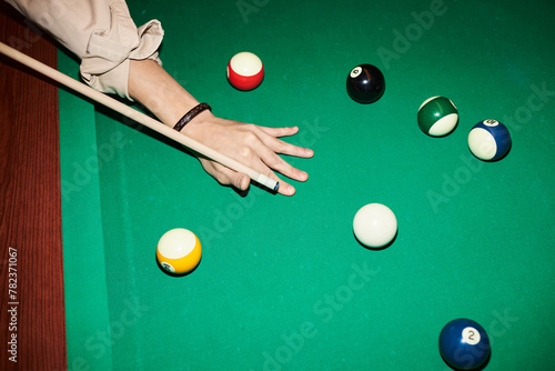 Quadro su tela Top view closeup of male hand holding cue stick and playing billiard at green po