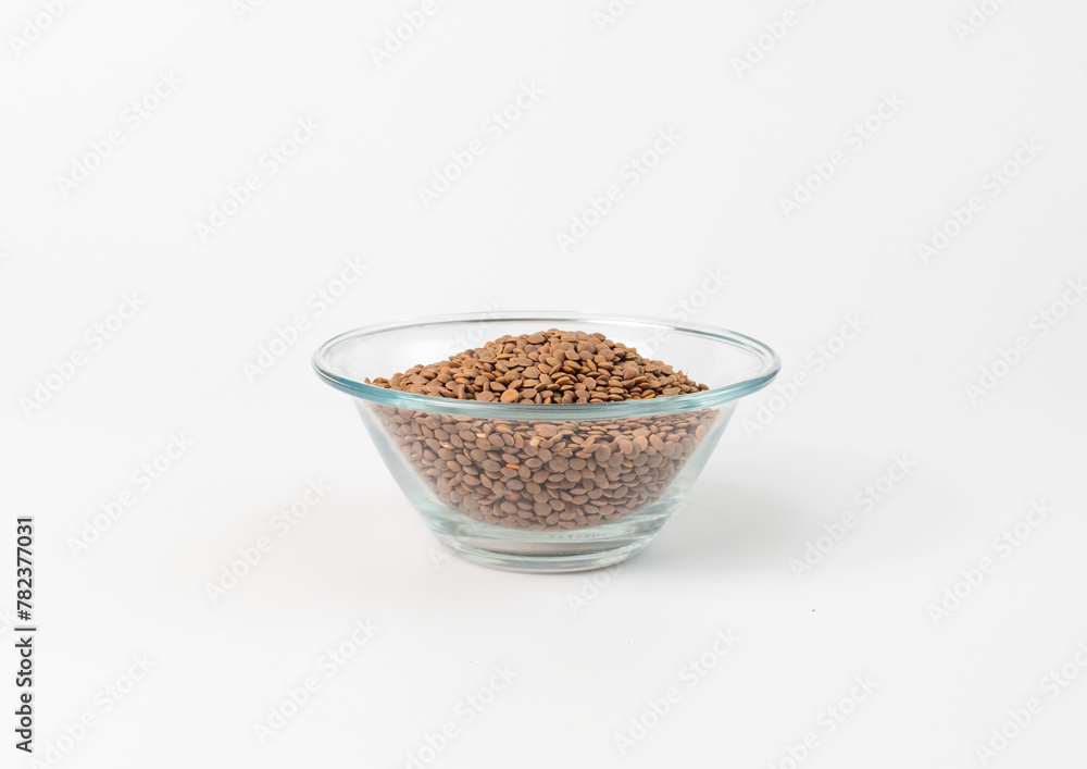 lentils are lying in a glass bowl on a white background lentils are lying in a glass bowl on a white background