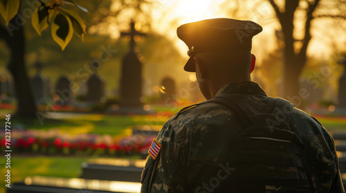 Rear view of a U.S. soldier looking at the sunset and a U.S. national flag. Memorial Day