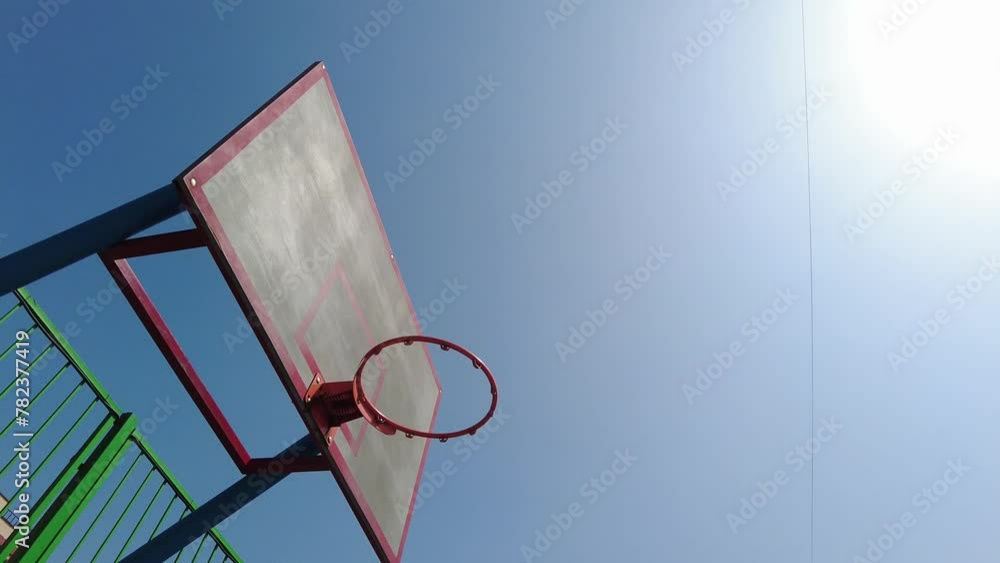 Basketball Hoop Rim Backboard Against Clean Blue Sky Basketball Hoop Rim Backboard Against Clean Blue Sky