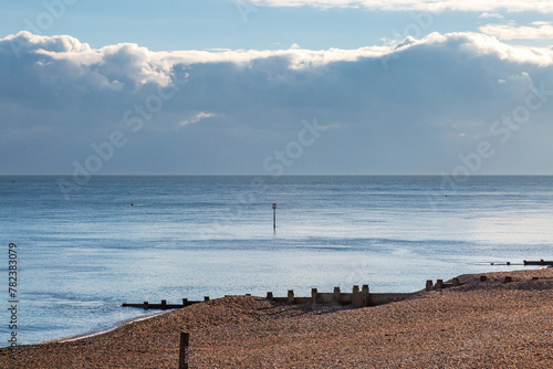 Looking over the pebble beach and wooden groynes at Eastbourne in Sussex, with the ocean behind