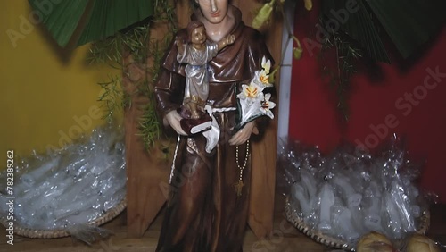 statue of Saint Anthony on a table decorated with bread