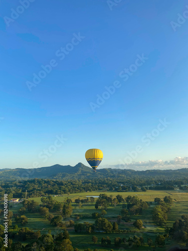 Hot air balloon in the morning sky over Australia, with nature and mountain in the background