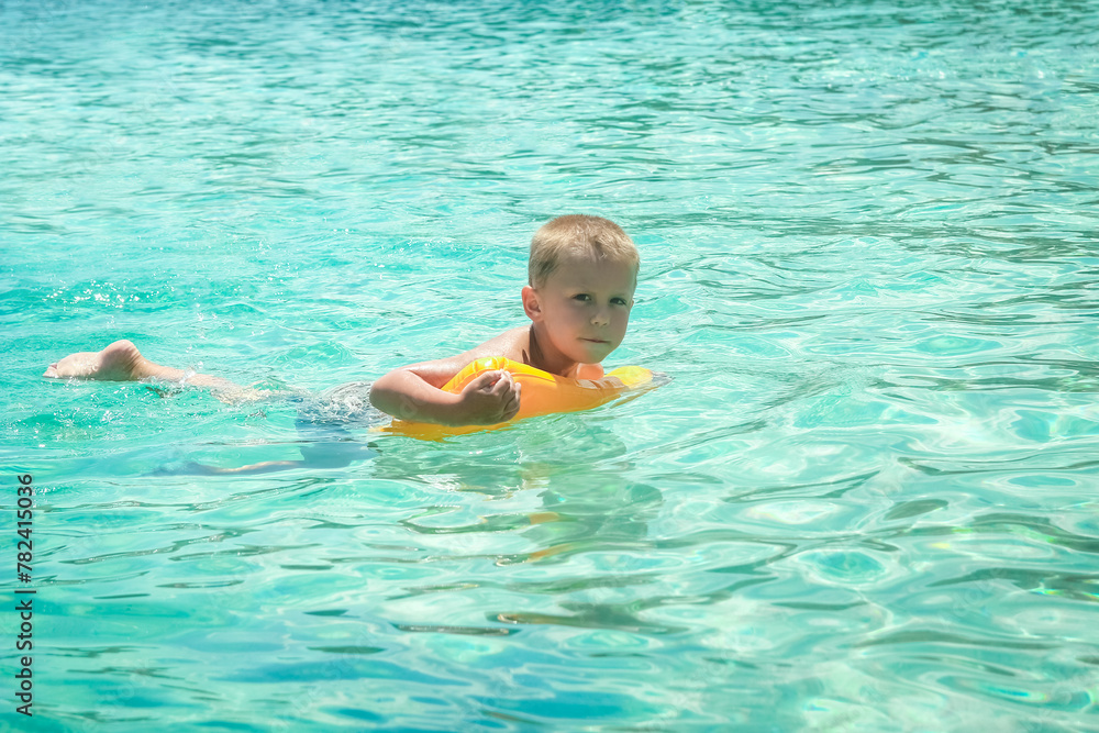 A Happy child swims near the shore in flippers in the sea of travel