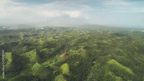 Aerial Philippines green jungle hills at Legazpi town, Asia. Tropical greenery forest with high trees, plants, grass and moss on ranges. Dusk summer day with cumulus grey clouds in dramatic shot