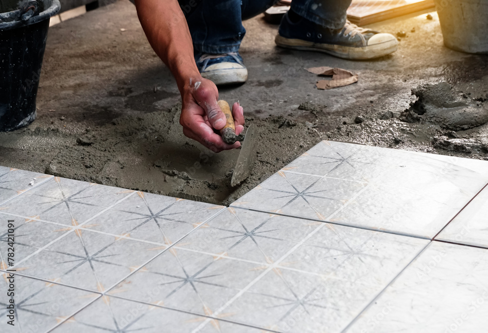 Floor tiles installation. Ceramic tiles and tools for tiler. Home improvement, renovation - ceramic tile floor adhesive, trowel with mortar, level. Floor tiles installation. Ceramic tiles and tools for tiler. Home improvement, renovation - ceramic tile floor adhesive, trowel with mortar, level.