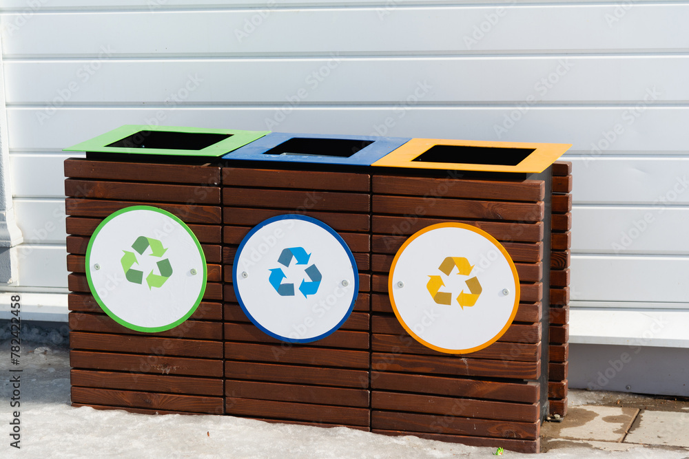 Recycling bins on city street. Collection of waste bins full of ...