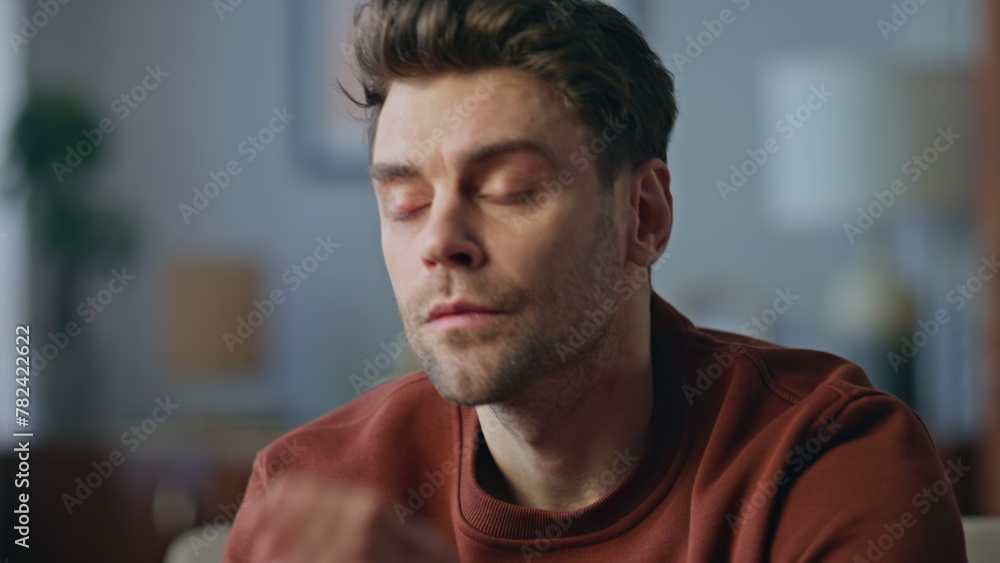 Pensive man sitting home in living room close up. Portrait serious guy thinking Pensive man sitting home in living room close up. Portrait serious guy thinking