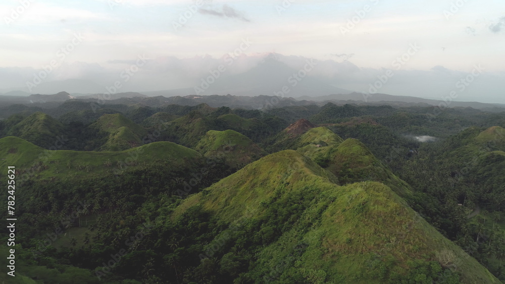 Aerial green mountain ranges at Mayon volcano, Legazpi, Philippines. Majestic Filipino hills at fog with high trees and grass. Nobody Asia landscape of tropic nature in National Park Quintinday