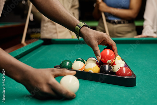 Canvas Print Side view closeup of hands putting billiard balls in triangle frame for pool gam