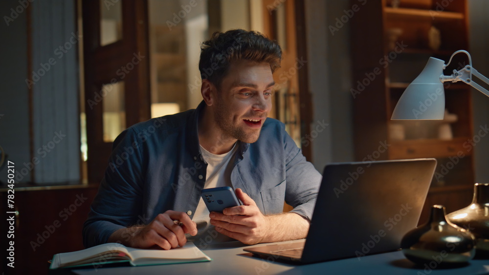 Smiling student videocalling computer at evening workplace closeup. Man talking Smiling student videocalling computer at evening workplace closeup. Man talking