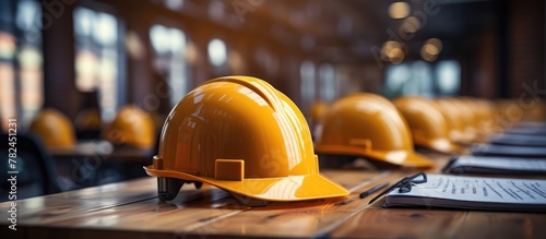 Yellow safety helmet blueprints on engineering desk, Construction concept © MBRAMO