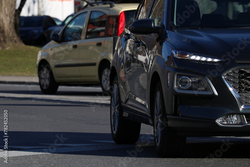 Tableau sur toile Cars driving on a road in an urban or suburban setting.