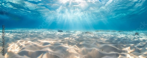 Serene underwater sunrays over sandy ocean floor