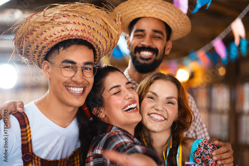 Friends sharing laughter and capturing memories at a festive Brazilian Junina celebration. Group of jovial companions in traditional attire taking a joyous selfie