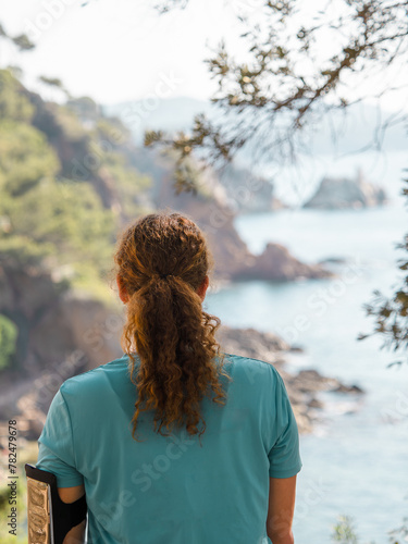 Rear View of a Contemplative Woman Overlooking the Rugged Coastline of Costa Brava