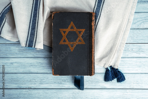 Old book Talmud, Hebrew Rabbinic Judaism, Jewish religious law. Torah, Hebrew Bible. Star of David on a dark cover. Holy Scripture containing the word of God. Antique edition, vintage worn paper photo