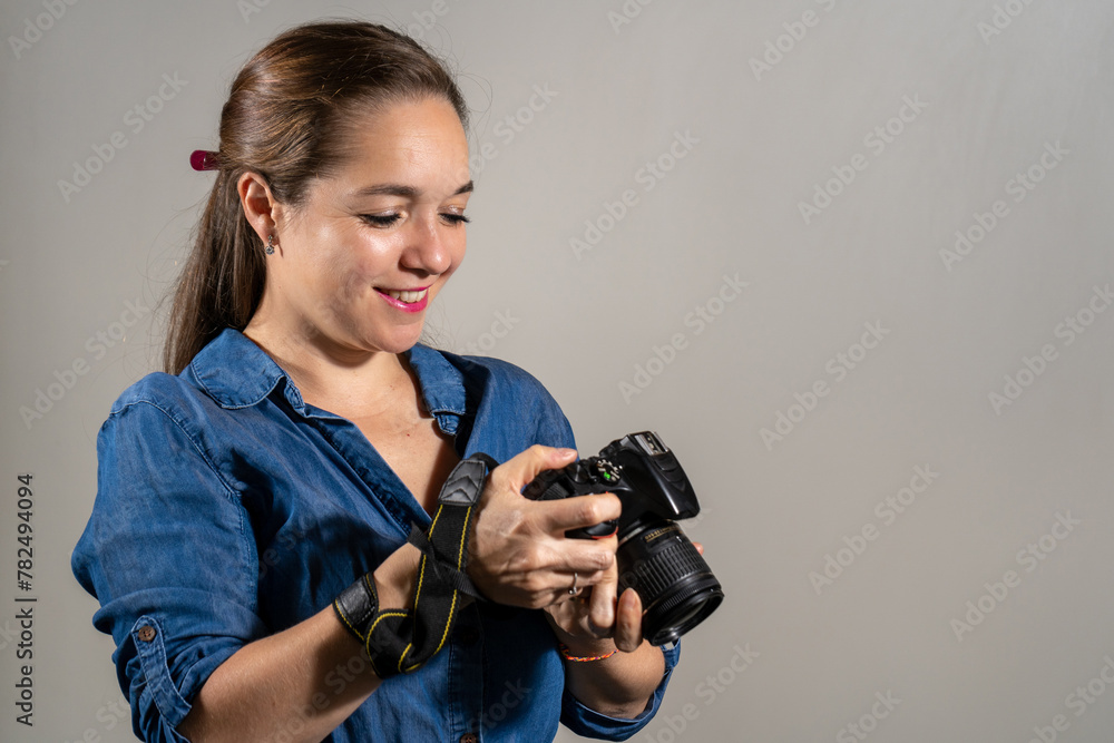 Mujer fotógrafa profesional usando su cámara y mirando la pantalla de su cámara Mujer fotógrafa profesional usando su cámara y mirando la pantalla de su cámara