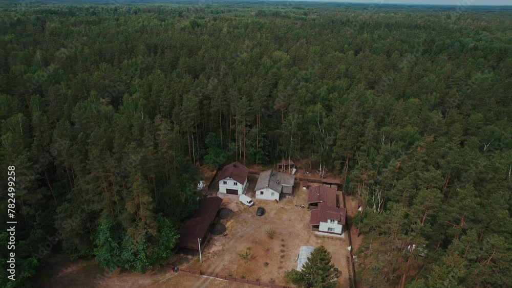 Aerial view of estate with residential and ancillary buildings in countryside surrounded by pine forest. Concept for development of livestock and crop production based on peasant farming Aerial view of estate with residential and ancillary buildings in countryside surrounded by pine forest. Concept for development of livestock and crop production based on peasant farming
