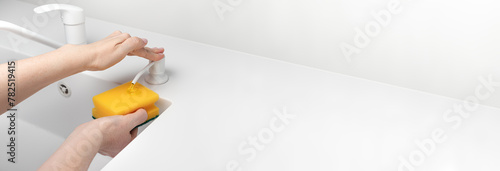 Fotografie Female hand press on built-in dispenser in the sink with detergent