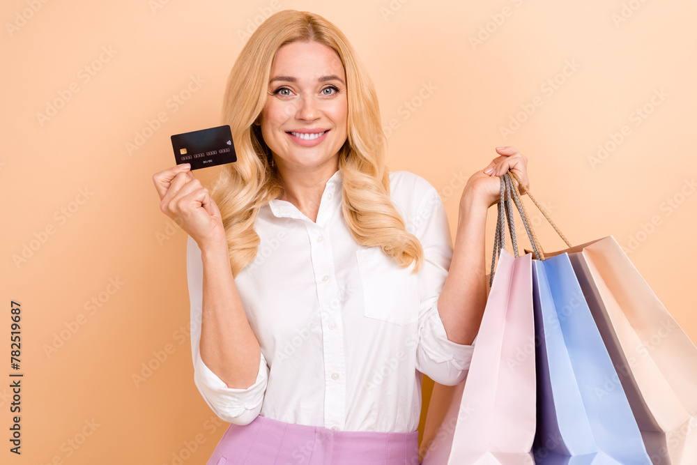 Photo of excited pretty woman wear white shirt rising bank card bargains isolated beige color background Photo of excited pretty woman wear white shirt rising bank card bargains isolated beige color background