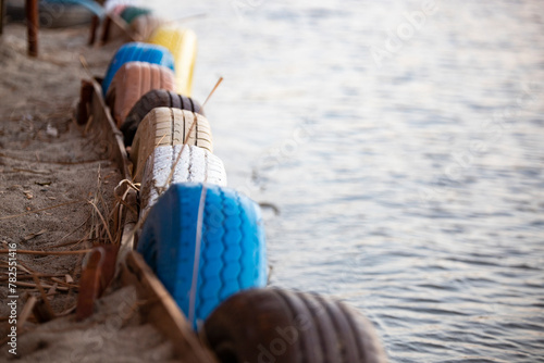 Colorful car tires on the beach. Selective focus with shallow depth of field. Close-up image with wheels in the coastline.