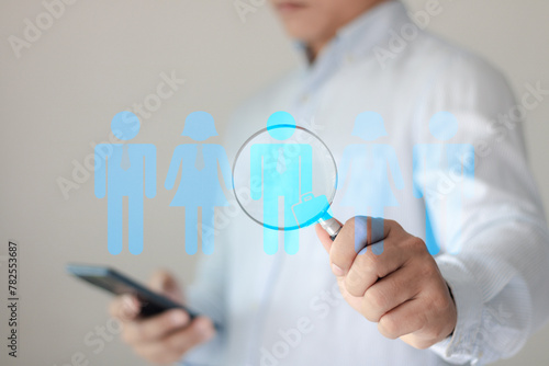 Human Resource Management, HRM, Customer Relationship Management, Customer Network Technology. Businessman holding magnifier for searching to human icon for human development and recruitment concept.