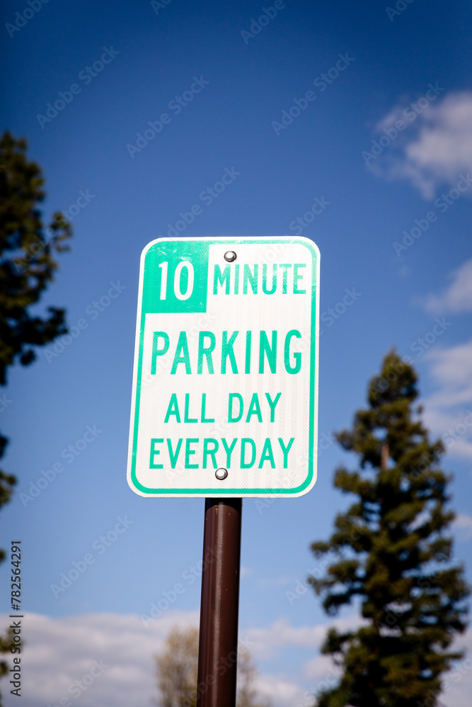 A white and green street pole road sign informing that only 10 minutes parking is allowed all day everyday at this spot