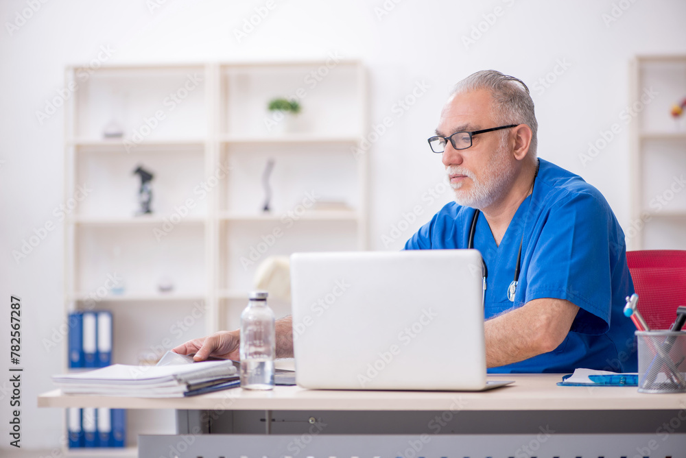 Old male doctor radiologist working in the clinic Old male doctor radiologist working in the clinic