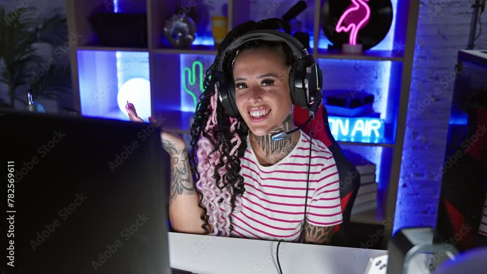 Triumphant hispanic amputee woman celebrates gaming victory indoors! cheering with ecstatic smile, headphones on and a winner expression in dark gaming room. Triumphant hispanic amputee woman celebrates gaming victory indoors! cheering with ecstatic smile, headphones on and a winner expression in dark gaming room.