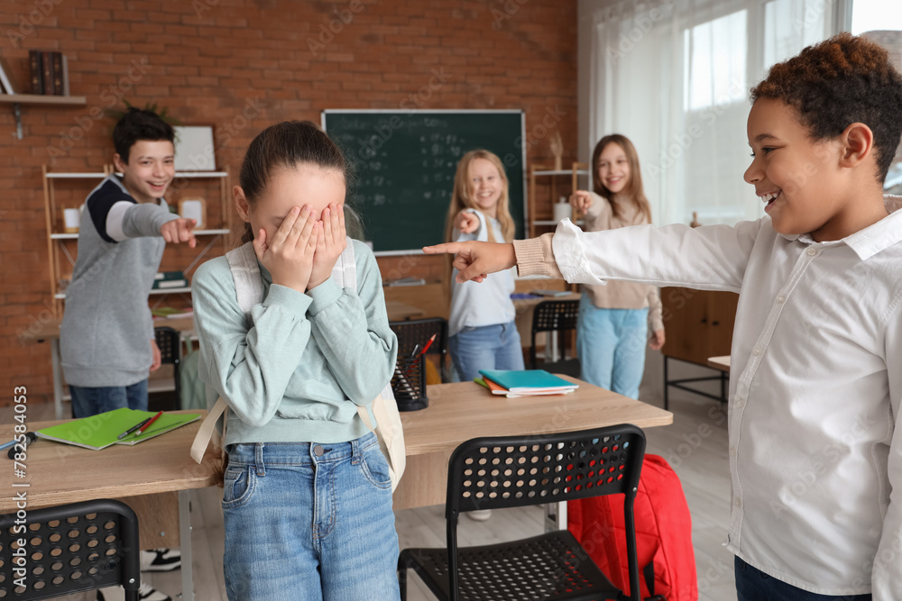 Bullied little girl with her classmates in classroom - obrazy, fototapety, plakaty 