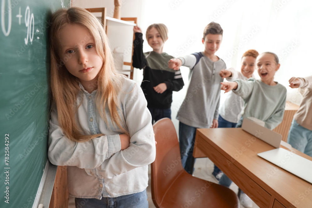 Bullied little girl during lesson in classroom Bullied little girl during lesson in classroom