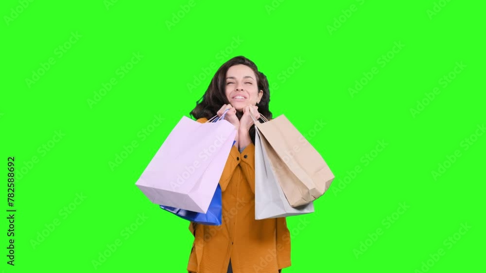 Beautiful young female shopper smiling happy with bags on the chroma key Beautiful young female shopper smiling happy with bags on the chroma key