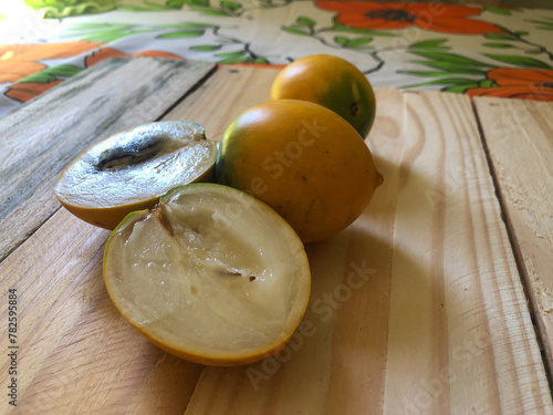 Abiu fruit cut on rustic wooden board ready for consumption photo