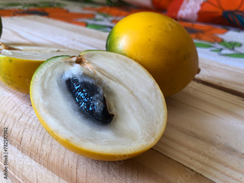 Abiu fruit cut on rustic wooden board ready for consumption photo