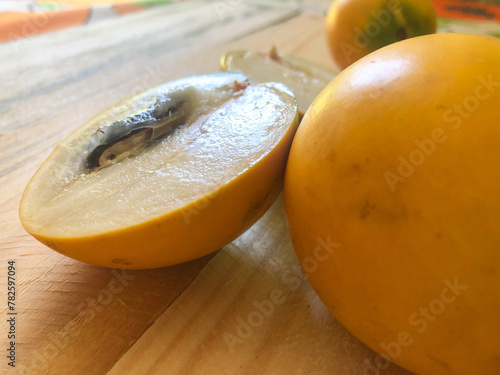 Abiu fruit cut on rustic wooden board ready for consumption photo