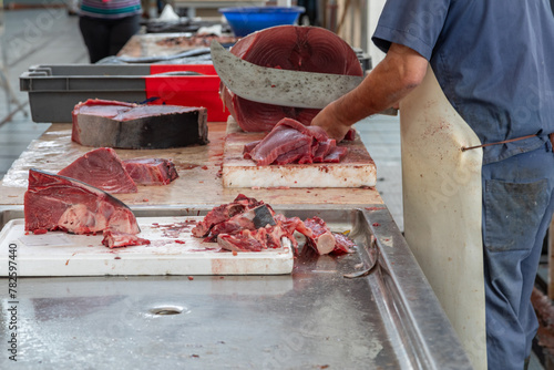 Fish Monger Cutting Tuna Steaks From a Whole Fish With a Large Cleaver in a Fish Market in Funchal, Madeira, Portugal