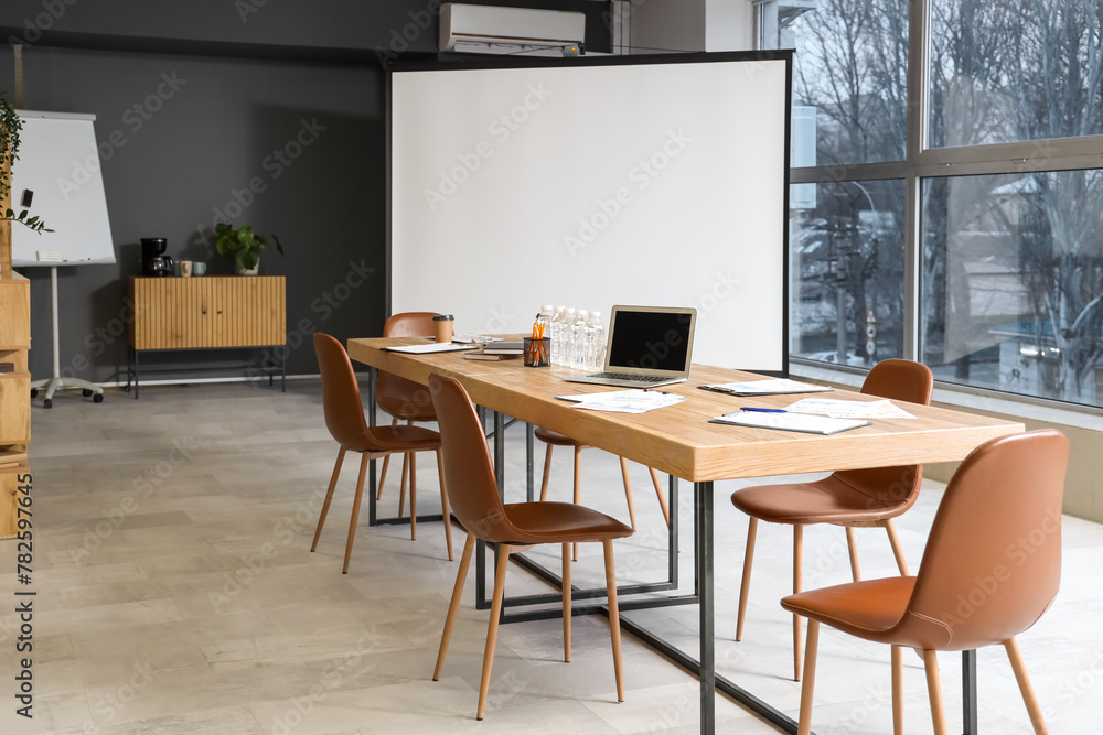 Interior of light modern conference hall with table, screen board and armchairs Interior of light modern conference hall with table, screen board and armchairs