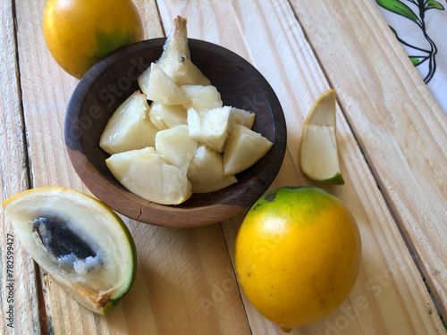 Abiu fruit cut in wooden bowl and served in dessert photo