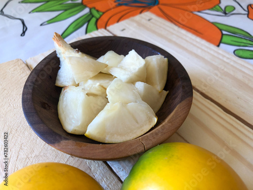 Abiu fruit cut on rustic wooden board ready for consumption photo