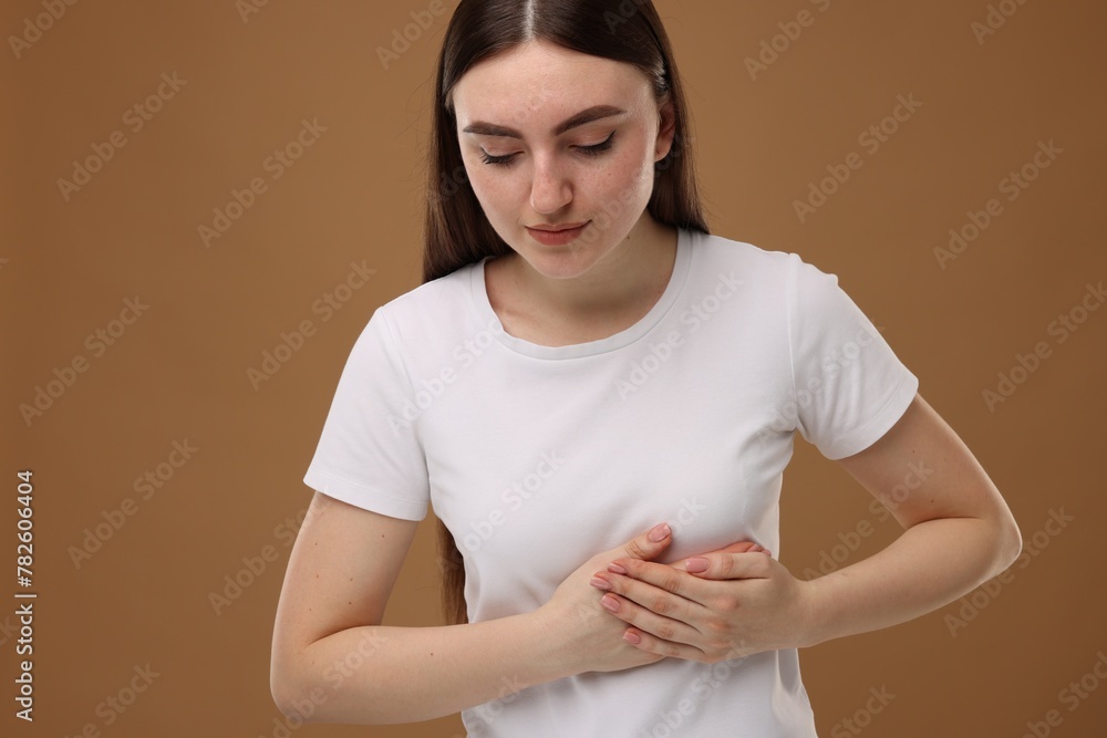 Obraz premium Woman having heart attack on brown background