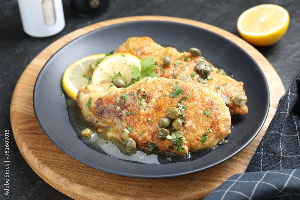 Delicious chicken piccata served on black table