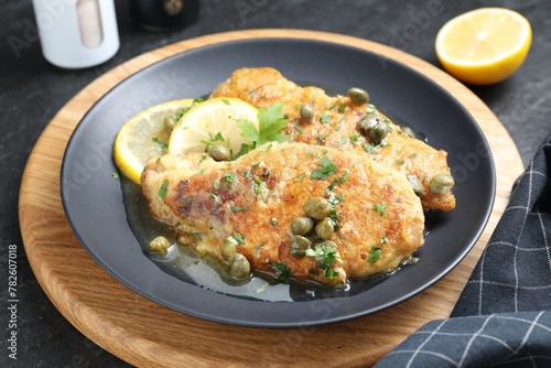 Delicious chicken piccata served on black table