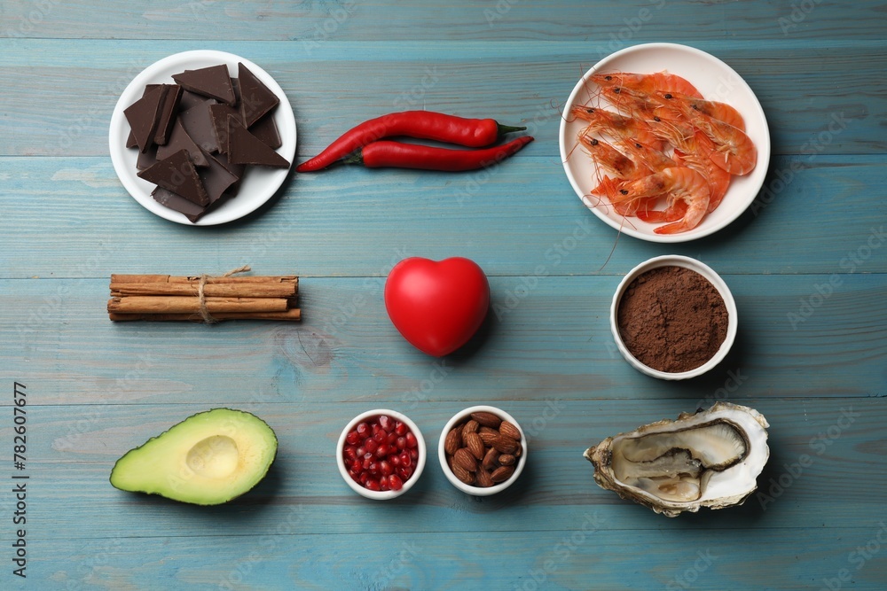 Natural aphrodisiac. Different food products and heart model on light blue wooden table, flat lay Natural aphrodisiac. Different food products and heart model on light blue wooden table, flat lay