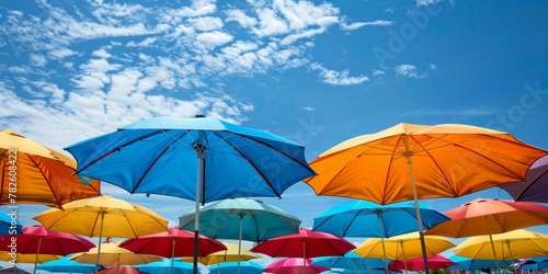 Colorful beach umbrellas under blue sky  multiple colors  summer vacation concept  outdoor relaxation theme. Copy space.