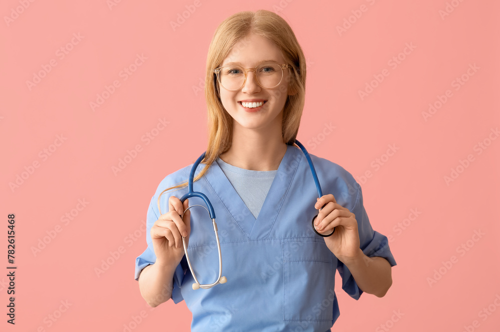 Female happy medical assistant with stethoscope on pink background Female happy medical assistant with stethoscope on pink background