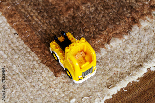 A Toy Construction Truck Resting on the Carpet, Bearing Signs of Play and Adventure